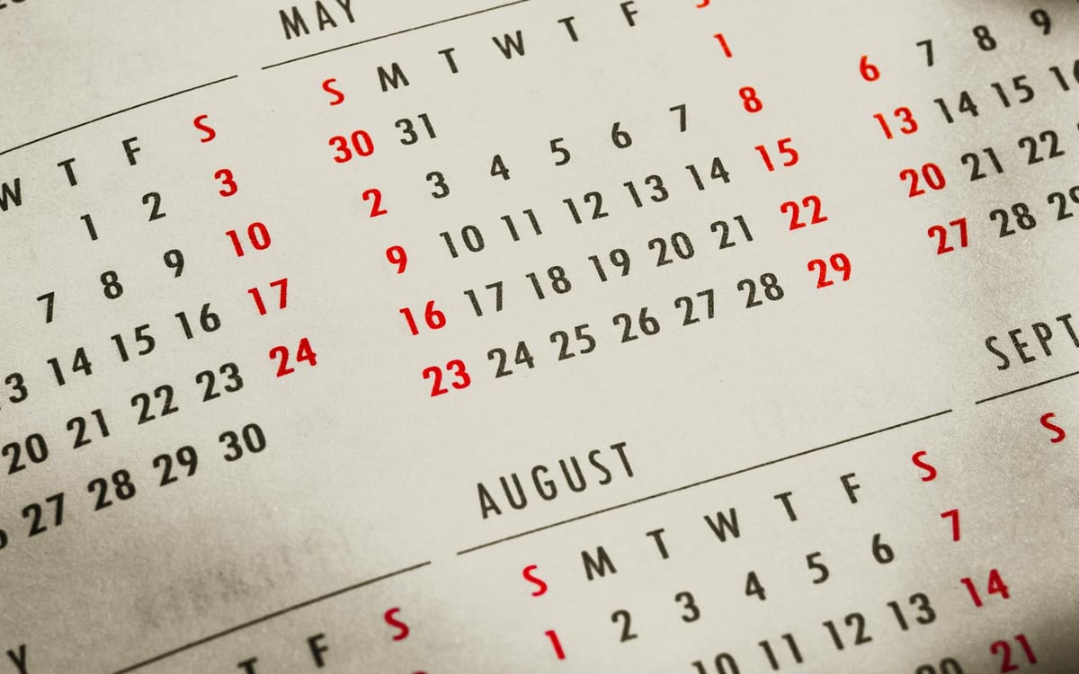 A printed yearly calendar spread showing several months at once — the whole compliance year visible on one page