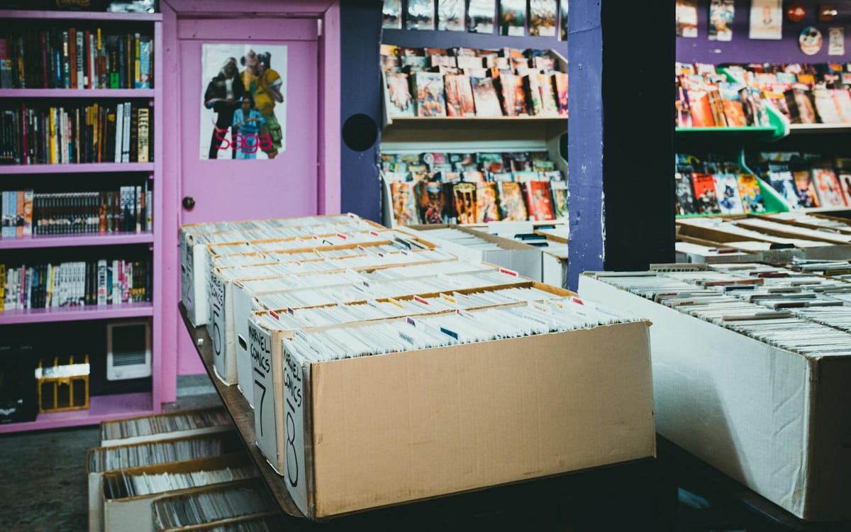 A comic-book store with long-boxes of bagged and boarded comics lined up for collectors to browse — the retail side of the pop-culture economy