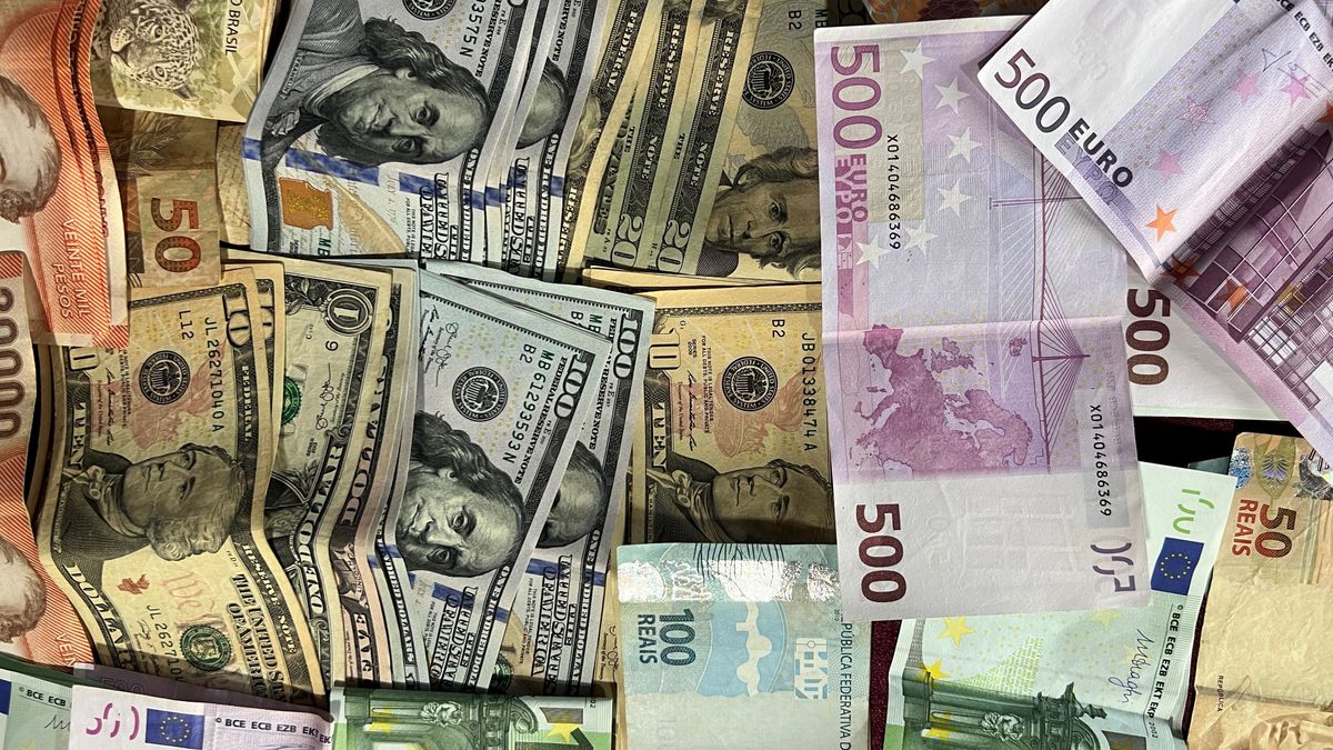 Des billets de nombreux pays — dollars américains, euros et autres — empilés ensemble sur un bureau, la portée multi-devises qu'ouvre une société à Hong Kong à un fondateur continental