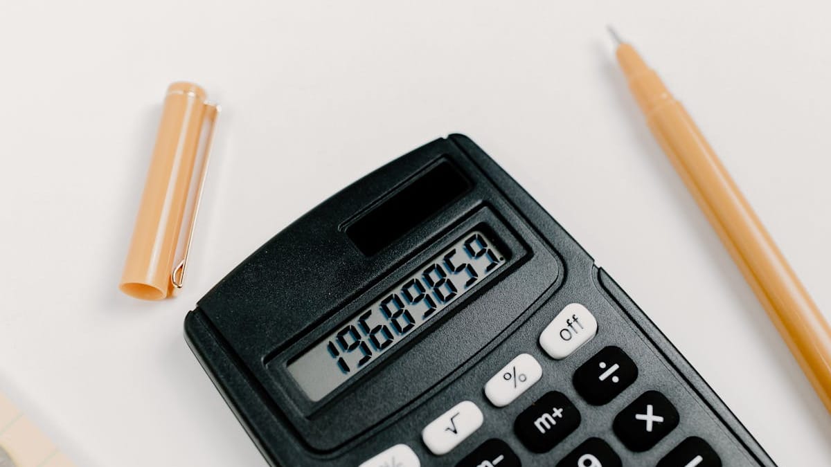 A black calculator with a pen on a clean white desk — a transparent look at what a Hong Kong company actually costs