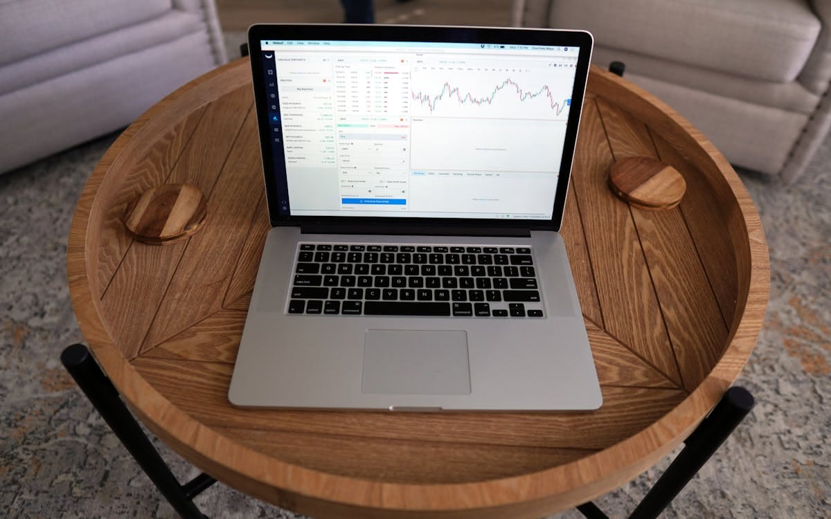 A laptop on a wooden table showing investment and portfolio charts — the kind of investments and reserves a Hong Kong holding company can hold
