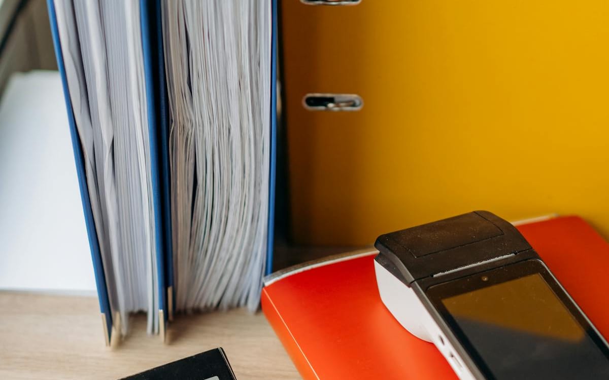 Lever-arch files of accounting paperwork stacked beside a calculator on a desk — the substantiating records behind a Hong Kong offshore profits claim